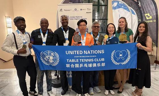 联合国乒乓球队成员在2026年第51届联合国机构间运动会期间合影。图左四为俱乐部主席黄武耀，左五为尤格什，左六为王宇舒，左八为努琳。
